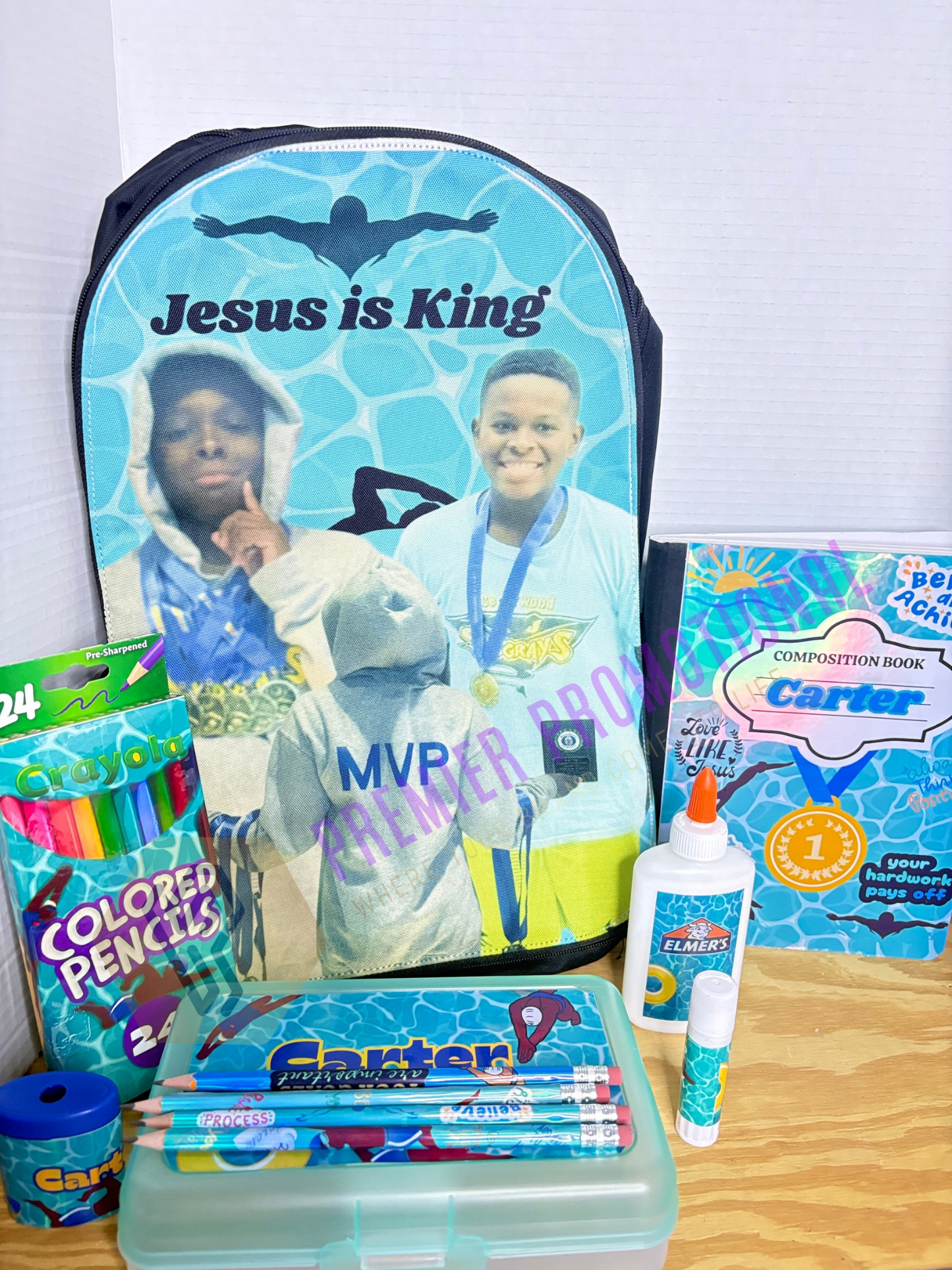 Backpack with 'Jesus is King' text and educational supplies on a wooden surface.