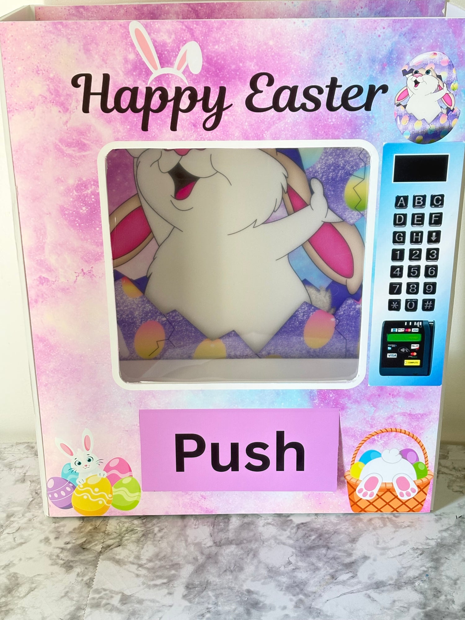 Easter-themed foam board vending machine with a cartoon bunny and colorful design on a marble surface.